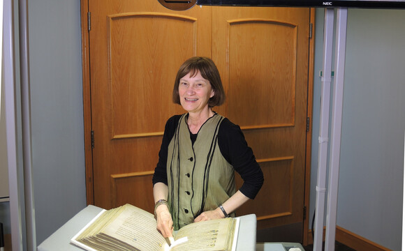 Rare Books Curator, Sandra Stelts with a facsimile of the BOOK OF KELLS and an illuminated initial letter, Spring semester 2017.