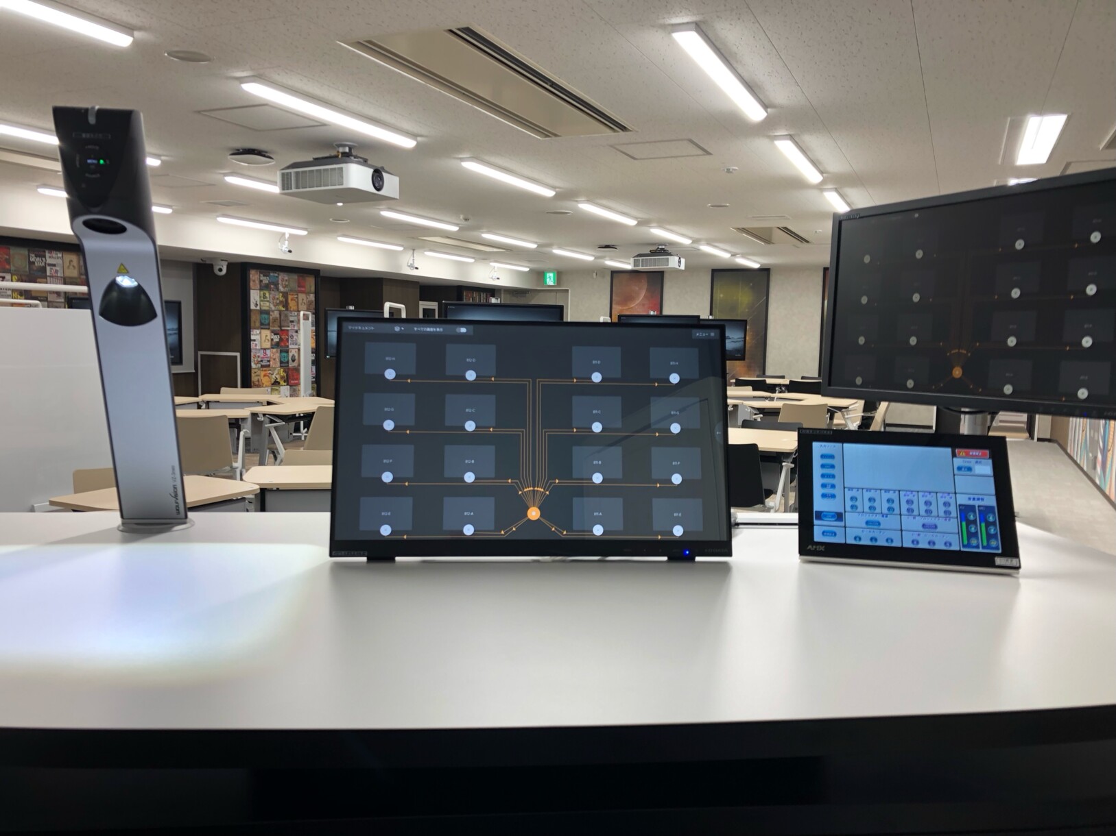 Lectern showing customised ‘Room View‘ with 16 workstations, facilitating easy drag & drop display of onscreen content, plus VZ-3neo Visualizer for display of physical content materials.